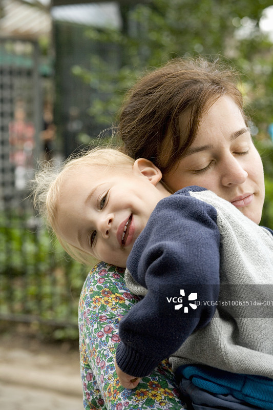 母亲抱着儿子(21-24个月)，闭着眼睛图片素材
