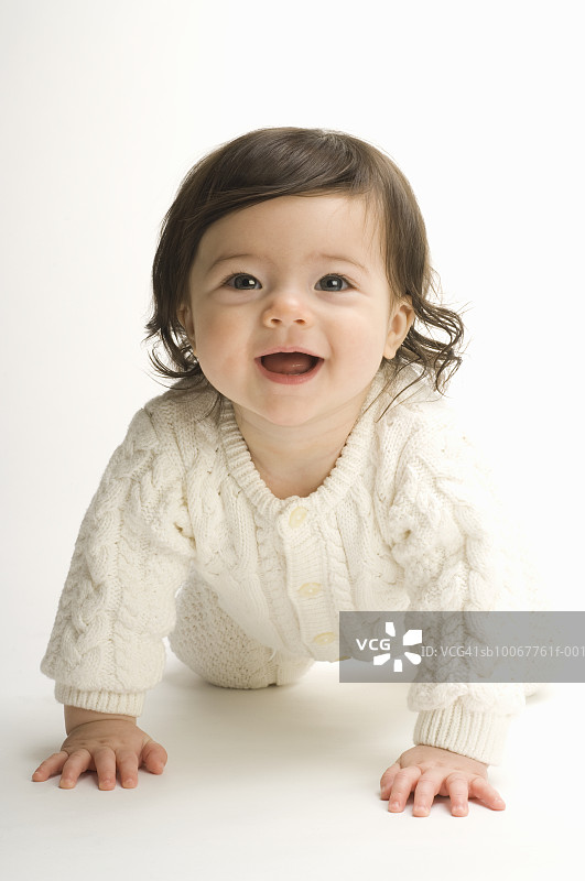 婴儿女孩的肖像(6个月)爬和笑图片素材