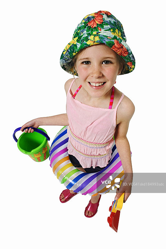 一个女孩(11-12)举着水桶和铁锹，腰上绕着救生圈图片素材