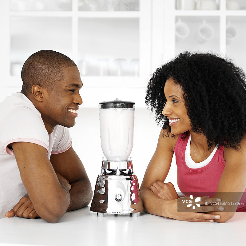 一对年轻夫妇在一个混合器上看着对方图片素材
