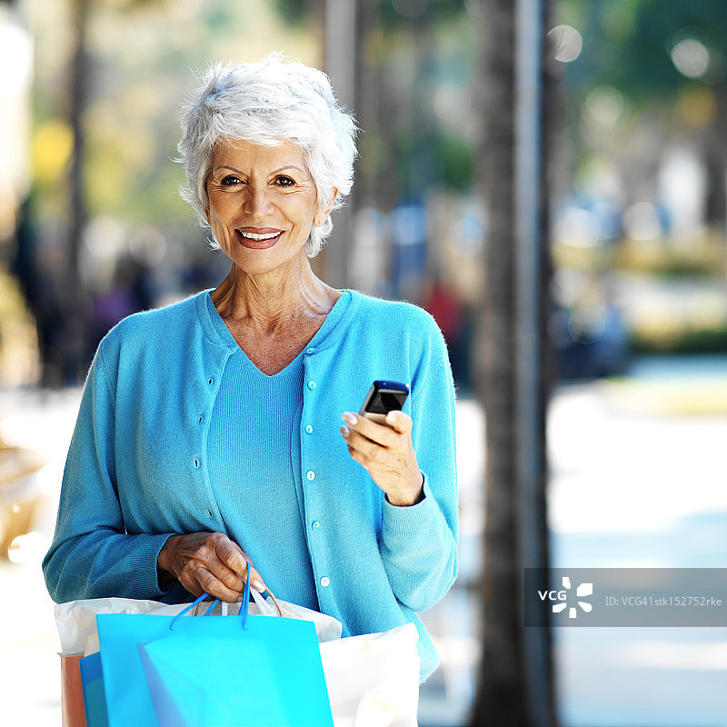一位拿着手机的老年妇女的肖像图片素材