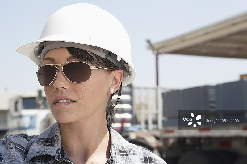 近距离观看女产业工人戴安全帽和太阳镜图片素材
