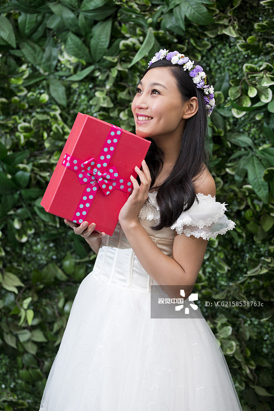 带花环的年轻女人抱着礼物盒图片素材