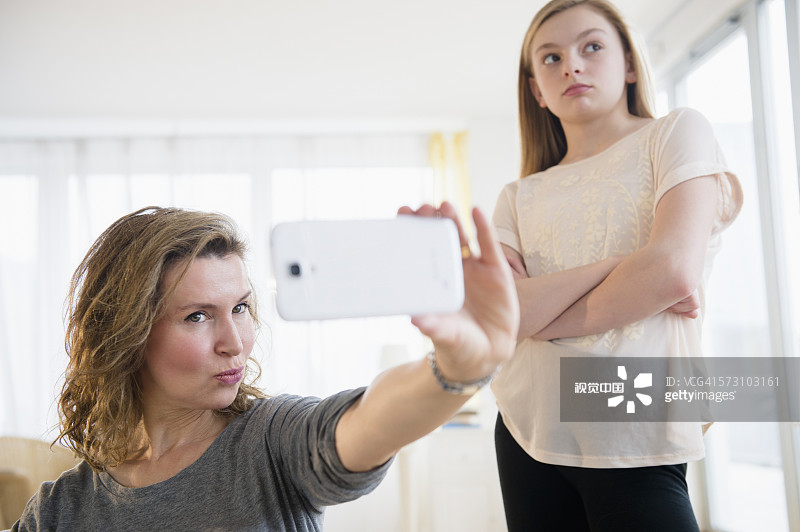 白人女孩尴尬的母亲用手机自拍图片素材