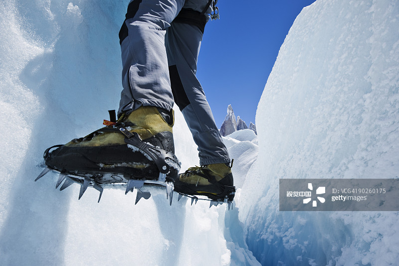 一个人的脚挂在冰冻的山坡上图片素材