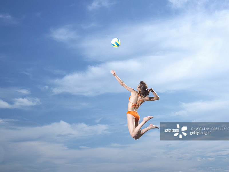一名年轻女子在空中击打排球图片素材