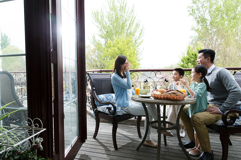 幸福家庭在阳台吃早餐图片素材
