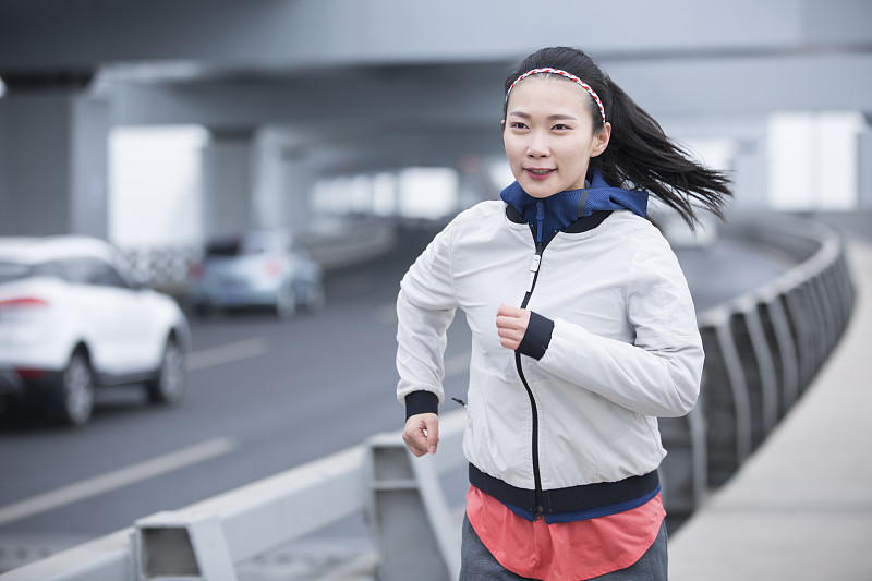青年女子在跨海大桥上跑步运动图片下载