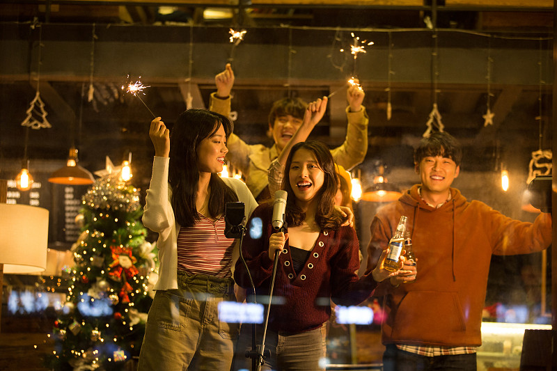 五个青年男女一起在咖啡馆放烟花唱歌庆祝平安夜和圣诞节图片素材