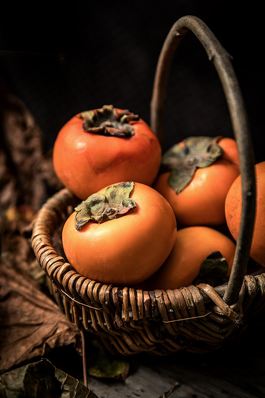 装在篮子里的金色秋天丰收的果实脆柿子水果图片素材