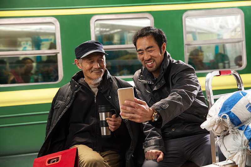 在火车站台上看手机的旅客图片下载