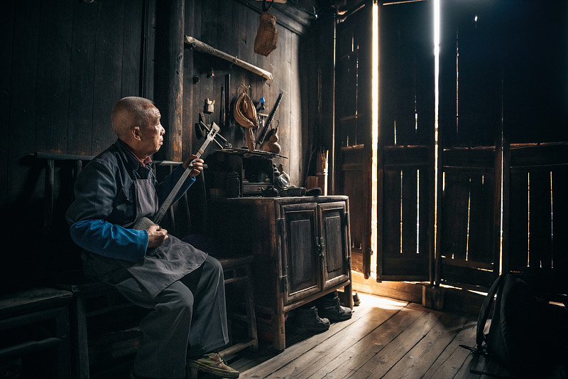 中国老人在室内弹奏长颈琵琶图片下载