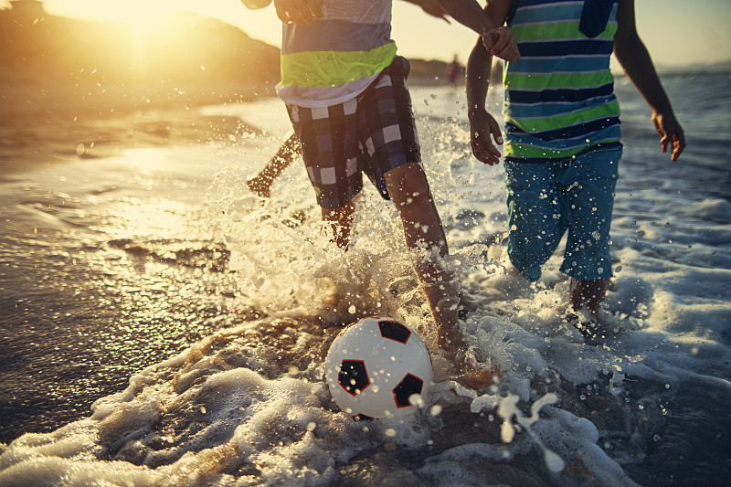 孩子们在海滩上踢足球图片下载