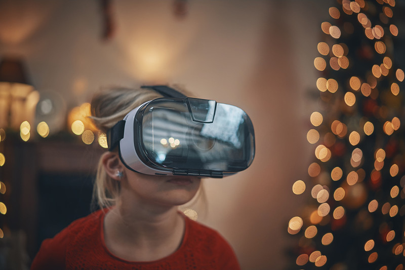 在舒适的圣诞氛围中，孩子们在客厅玩VR眼镜图片下载