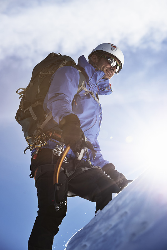 Mountain climber ascending mountain in bright sunlight, Chamonix, Rhone-Alps, France图片素材