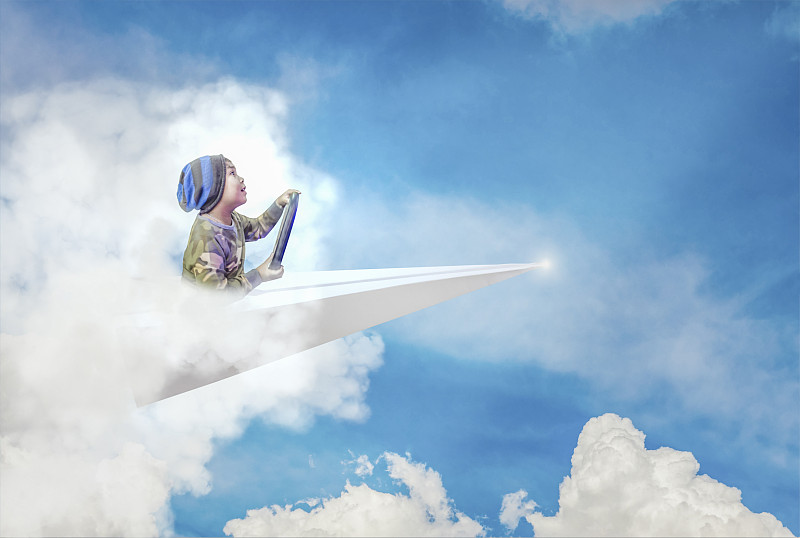 数字合成图像的男孩坐在纸飞机对天空图片素材