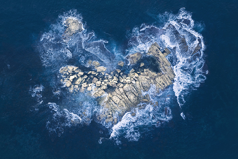 海浪冲击着心形的岩石岛图片下载