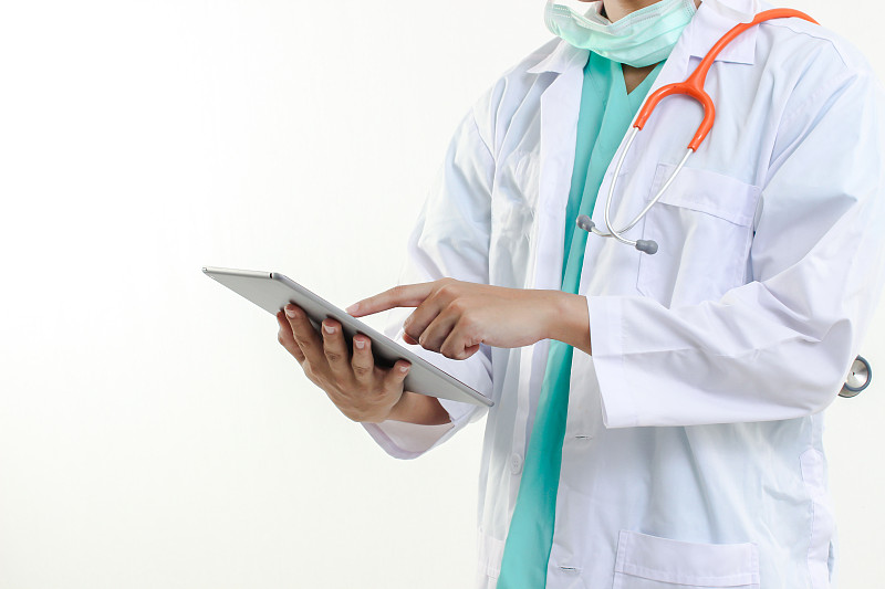 在白色背景下使用数字平板电脑的医生的腹部图片素材