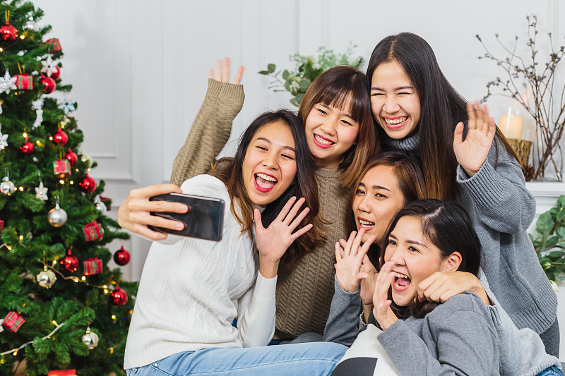 一群快乐的女性朋友在家里用手机自拍图片素材
