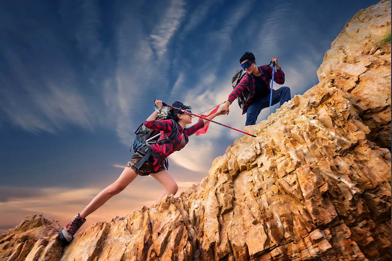 亚洲夫妇徒步登山，帮助登山。团队和领导的概念。度假，露营，旅行和放松的概念。图片下载