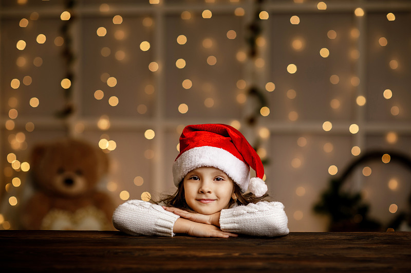 快乐的小女孩戴着圣诞老人的帽子图片下载