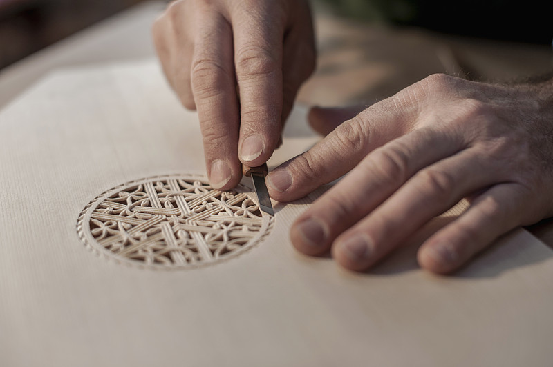 琵琶制造商雕刻出装饰的木材图片下载