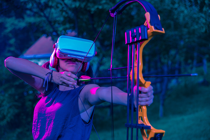 在虚拟现实中练习射箭的少女图片下载