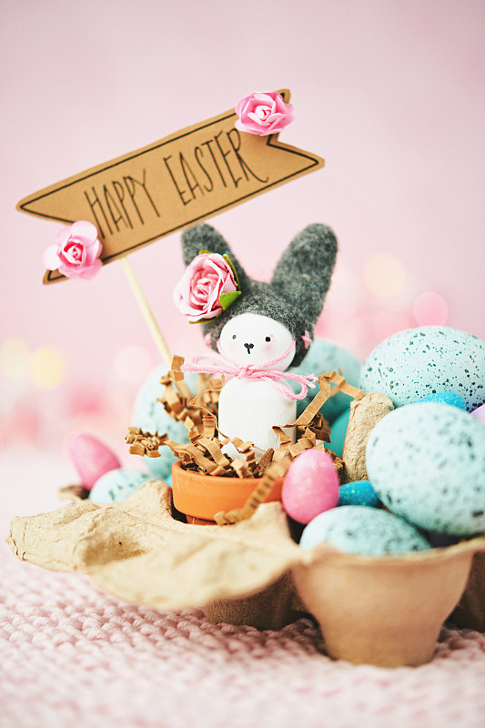 手工制作的复活节兔子在纸板蛋盒与快乐复活节信息图片素材