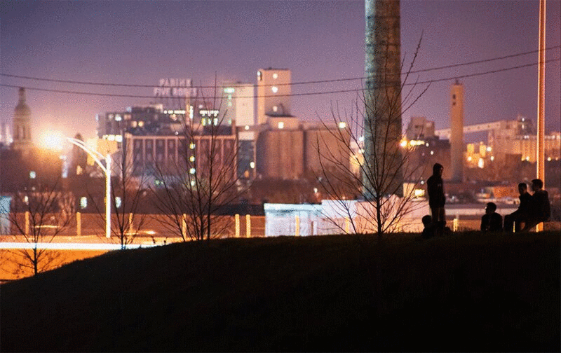 一群男孩在夜晚的城市景观中剪影图片下载