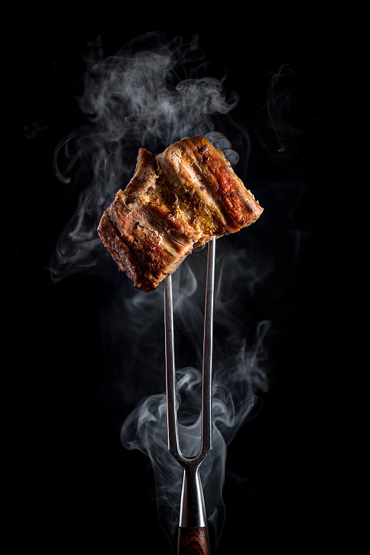 叉子与烤肉块的黑色背景图片下载