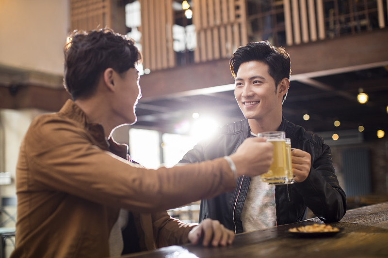 快乐的年轻男士在酒吧喝酒干杯图片下载