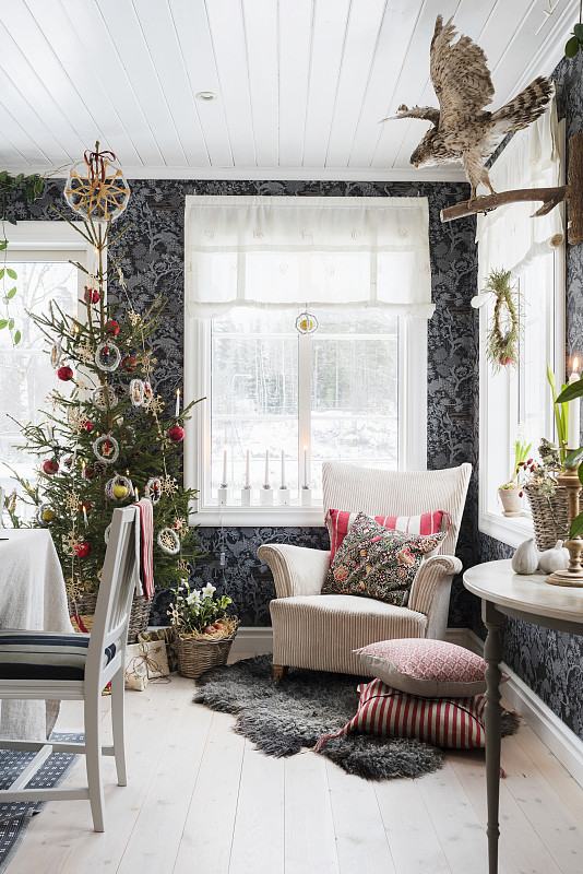 扶手椅和圣诞树映衬着黑色图案的墙纸图片素材
