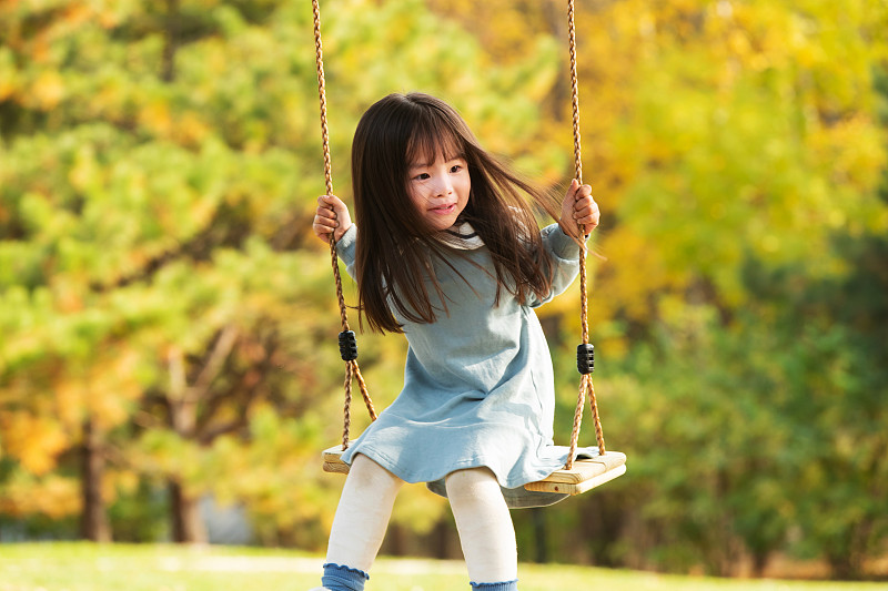 在公园里荡秋千的快乐女孩图片素材