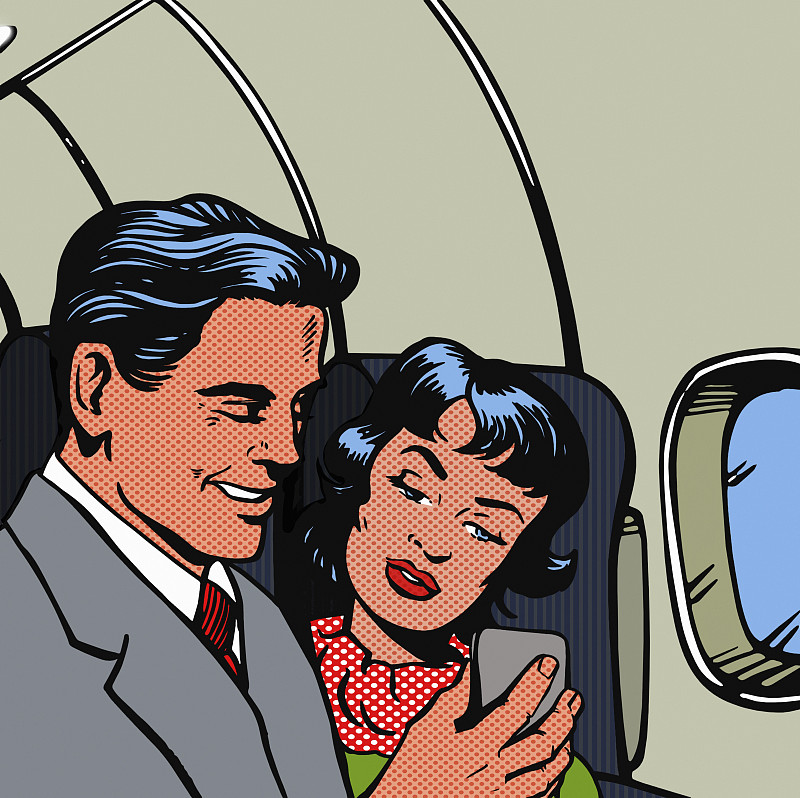 一名男子和一名女子在飞机上用智能手机阅读信息图片素材