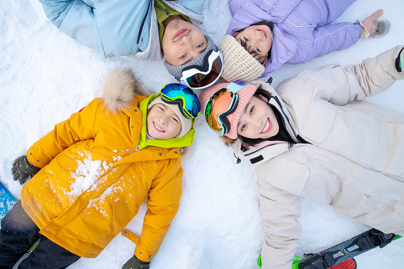 幸福的一家四口躺在雪地上图片下载