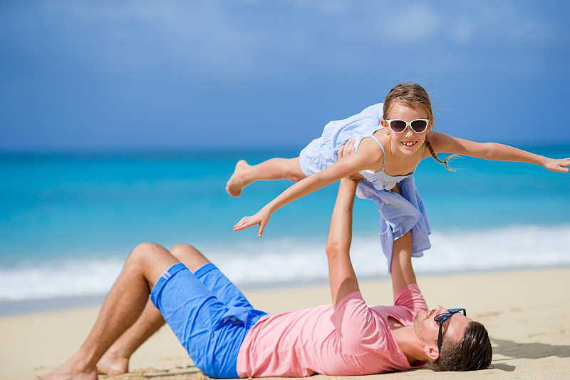 女儿和父亲在沙滩上玩耍图片素材