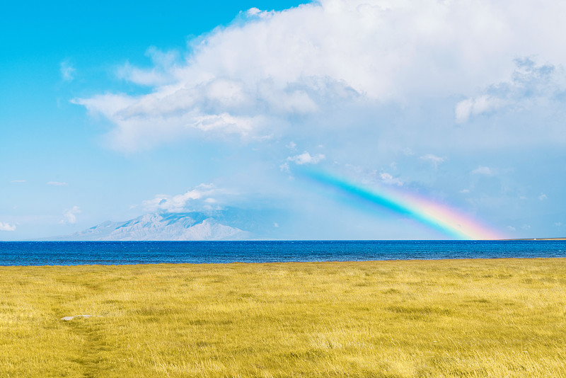 云层雪山彩虹湖泊和金黄的草原组成的圣山图片下载