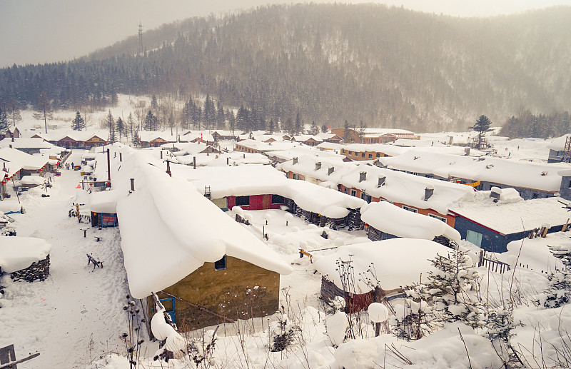 雪乡大山下白雪皑皑的村庄图片素材