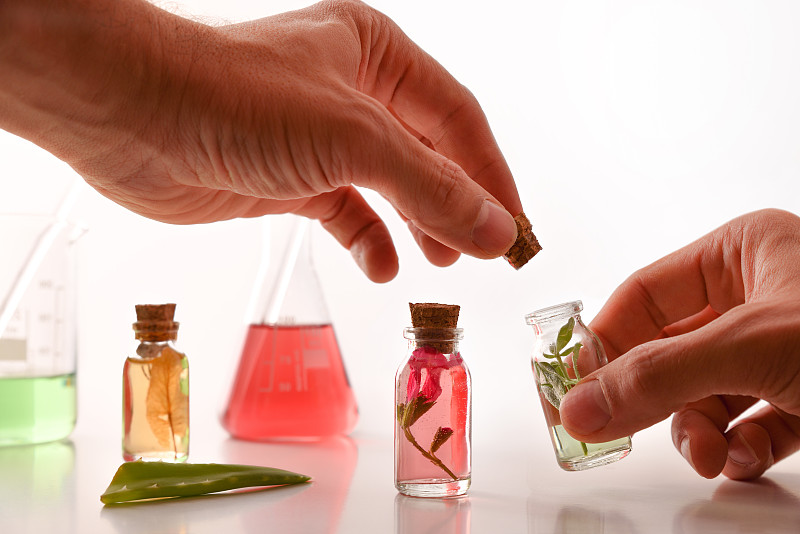 实验室中药师用手关闭装有天然香精的小瓶图片下载