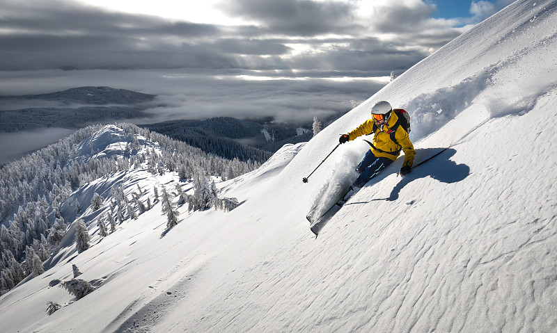 斯洛文尼亚Pokljuka，一名男子在白雪皑皑的山上滑雪图片下载