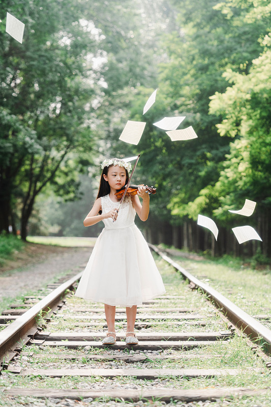 小女孩在户外拉小提琴图片素材