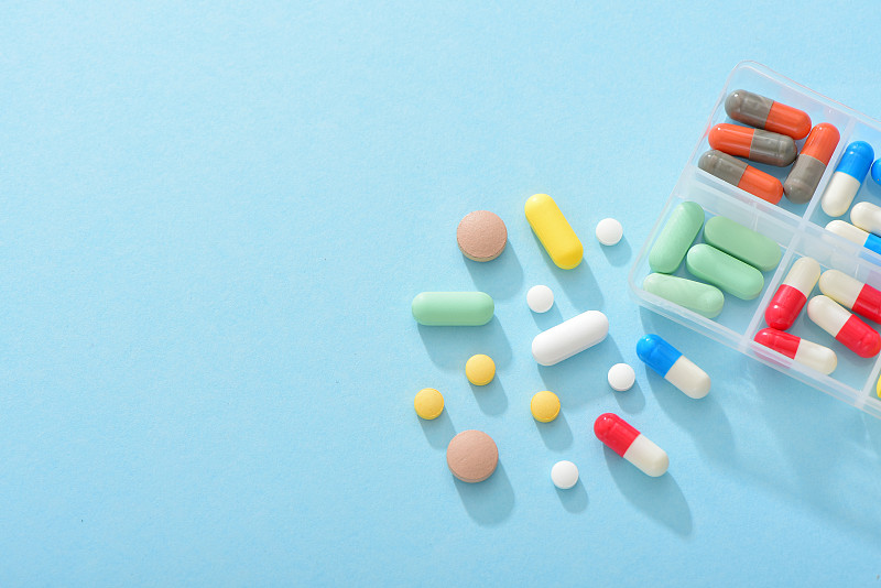 蓝色背景上的大量药品药物——医疗健康概念图片下载