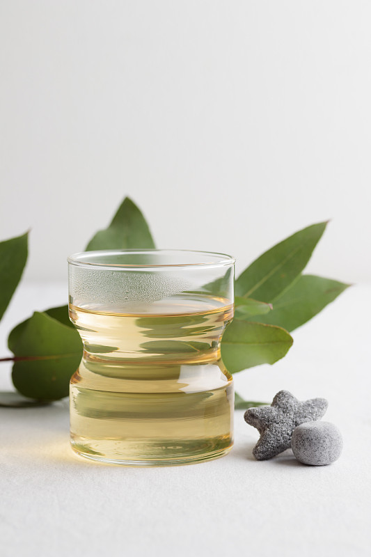 一杯新鲜的绿茶和甘草糖放在白色的桌子上图片下载