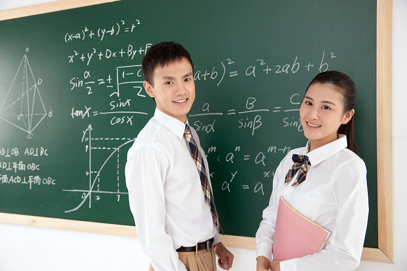 两个中学生站在黑板前图片素材