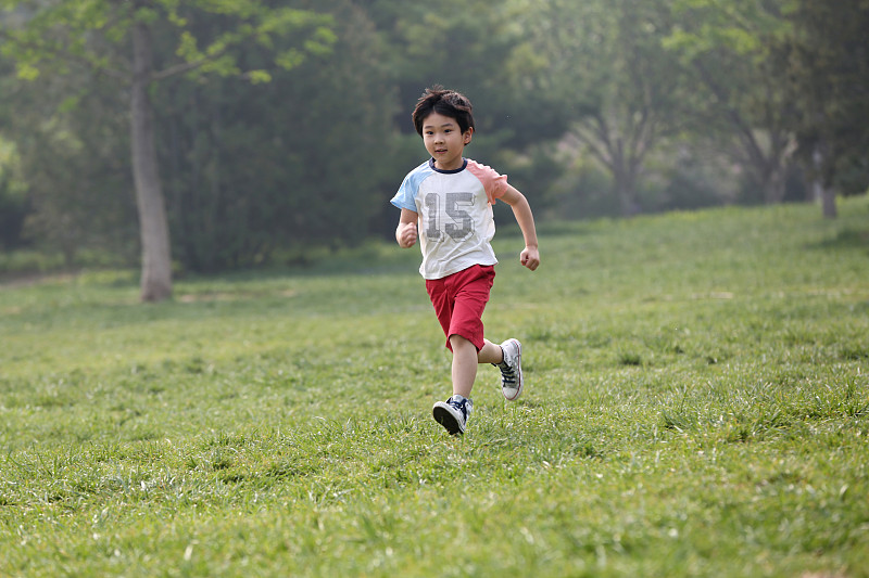 小男孩在草地上奔跑图片下载