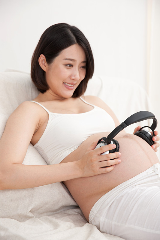 孕妇拿耳机放在肚子上胎教图片下载