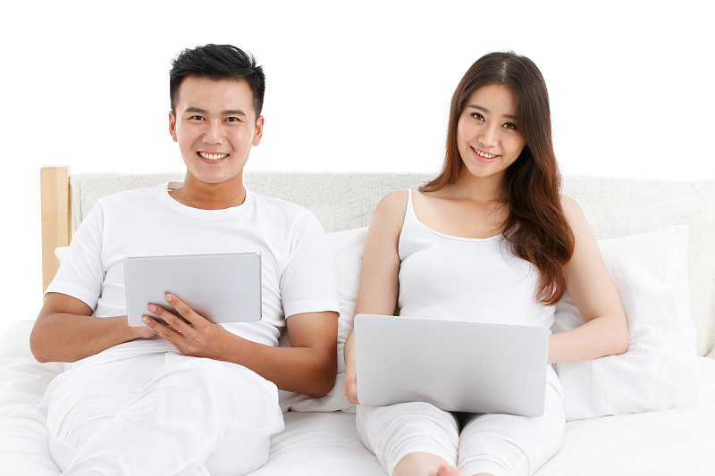 青年夫妇在床上使用电脑图片下载