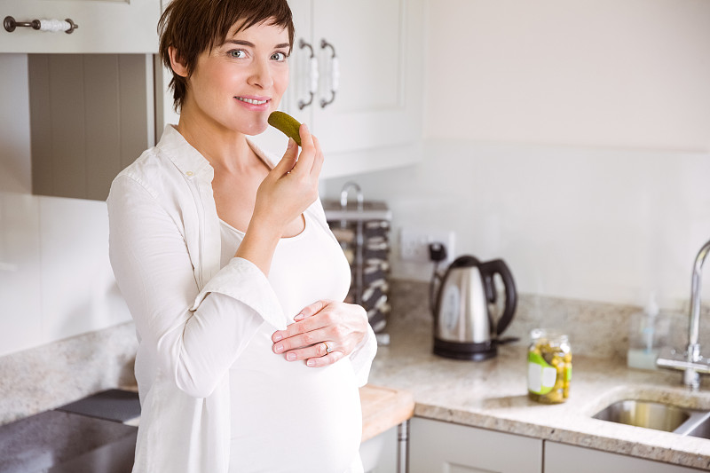 孕妇在家厨房吃泡菜图片素材