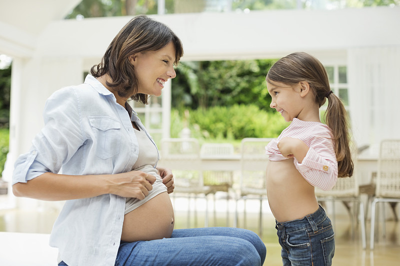 女孩和怀孕的母亲比较肚子图片下载