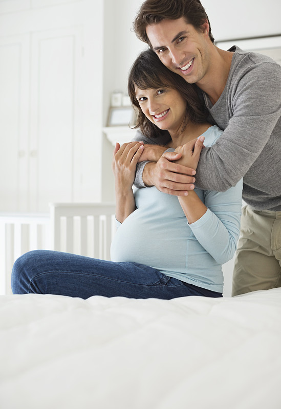 男人在床上拥抱怀孕的女友图片素材